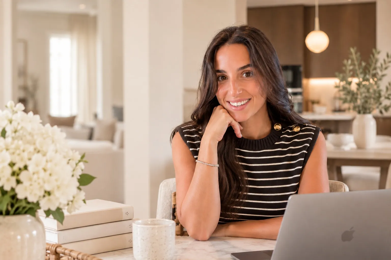 Rebeca, fondatrice de Spanish Mum in Paris, souriante à sa table de travail dans un intérieur lumineux